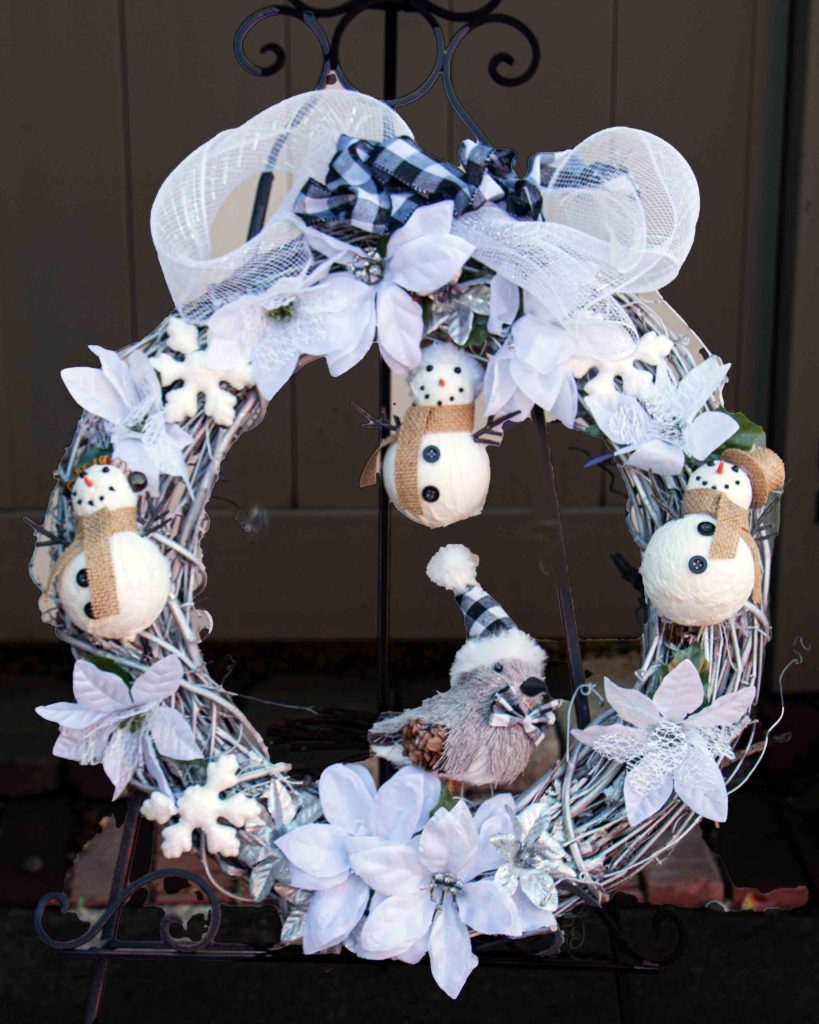 Winter wreath with snowman decorations and a snowbird ornament